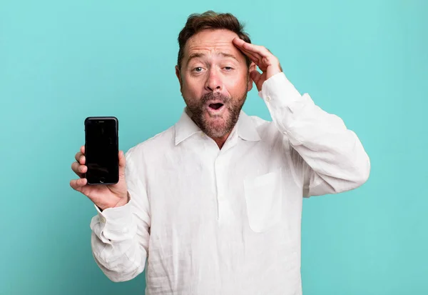 中年男性の幸せそうな驚きと驚き スマートフォンを見せると — ストック写真