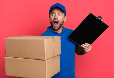 Orta yaşlı paketçi. Futbol topuyla şirket çalışanı konsepti spor koçu konsepti