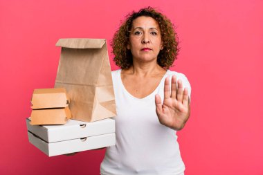 looking serious showing open palm making stop gesture. take away fast food delivery concept.