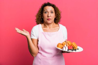 Oldukça orta yaşlı bir kadın şaşkın, şaşkın ve şüpheci hissediyor. Ev yapımı waffle konsepti