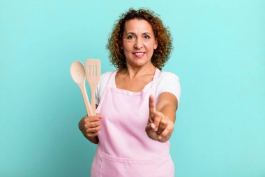 Güzel orta yaşlı kadın gururla gülümsüyor ve kendinden emin bir numara oluyor. ev hanımı şef konsepti