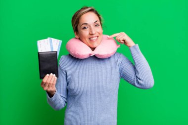 Güzel sarışın kadın kendi gülüşünü göstererek kendine güvenerek gülümsüyor. uçuş yolcu kavramı