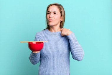 pretty blonde woman feeling stressed, anxious, tired and frustrated. japanese noodles concept
