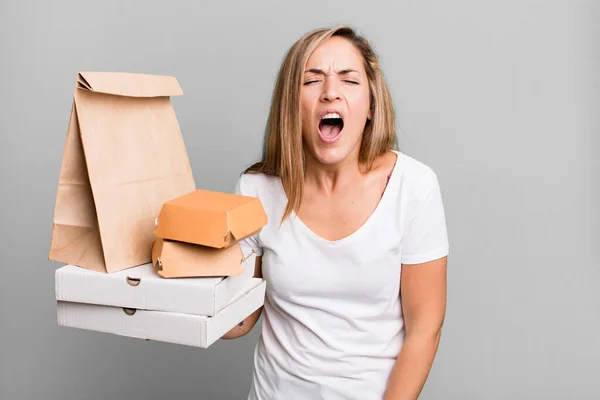 かなりブロンドの女が積極的に叫んでるとても怒ってる 配送は食品パッケージの概念を取り除き — ストック写真