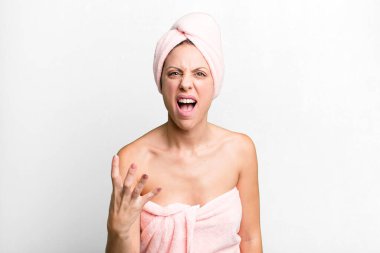 pretty blonde woman looking angry, annoyed and frustrated. bathrobe and beauty concept