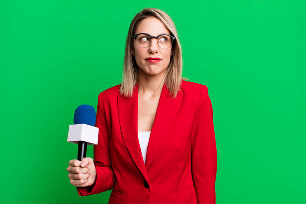 красивая блондинка грустит, расстроена или злится и смотрит в сторону. ведущий или журналист с микрофоном