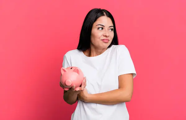 Hispanic Pretty Woman Shrugging Feeling Confused Uncertain Piggy Bank — Foto Stock
