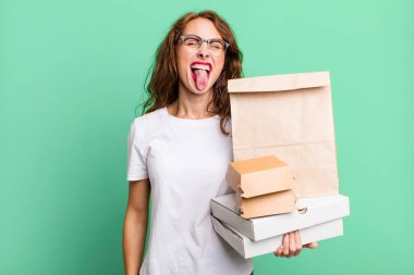 Neşeli ve asi tavırlı, şaka yapan ve dilini dışarı çıkaran İspanyol asıllı güzel bir kadın. Fast food paketleri kavramını kaldır