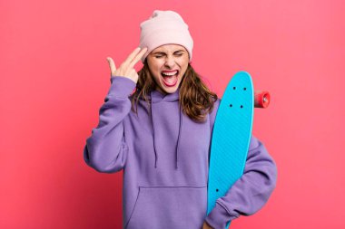 İspanyol güzel kadın mutsuz ve stresli görünüyor, intihar jesti silah işareti yapıyor. kaykay konsepti