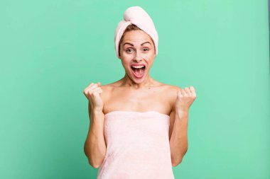 İspanyol güzel kadın şoke olmuş, gülüyor ve başarıyı bornoz giyerek kutluyor. güzellik konsepti