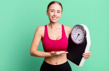 caucasian pretty woman smiling cheerfully, feeling happy and showing a concept. fitness and diet concept