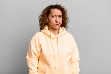 Orta yaşlı İspanyol kadın kafası karışık ve şüpheli, merak içinde ya da karar vermeye çalışıyor.