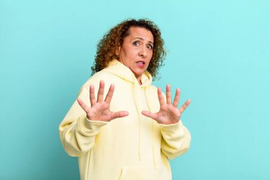 Orta yaşlı İspanyol kadın korkmuş, korku ve panik içinde geri çekiliyor ve bir kabusa tepki veriyor.