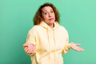 Orta yaşlı İspanyol kadın kafası karışık ve kafası karışık. Doğru cevap ya da karardan emin değil. Bir seçim yapmaya çalışıyor.