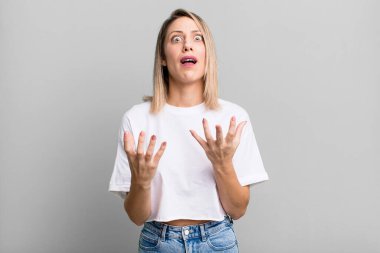blonde adult woman looking desperate and frustrated, stressed, unhappy and annoyed, shouting and screaming
