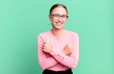 Neşeli bir şekilde gülümseyen ve kutlayan, yumruklarını sıkan, kollarını kavuşturan, mutlu ve pozitif hisseden