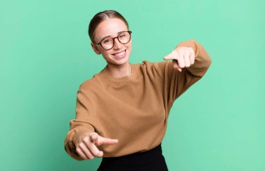 Mutlu ve kendinden emin hissetmek, kameraya iki elinle işaret etmek ve gülmek, seni seçmek.