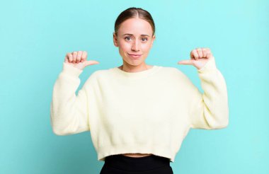 Gururlu, kibirli ve kendinden emin, tatmin olmuş ve başarılı görünüyor, kendini işaret ediyor.