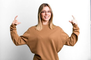 Sarışın, güzel bir kadın kendi gülüşünü çiziyor, iki eliyle, olumlu ve mutlu görünüyor, sağIık kavramı.