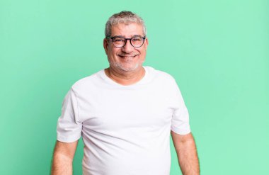 Büyük, dostane, kaygısız bir gülümsemesi olan orta yaşlı bir adam. Olumlu, rahat ve mutlu görünüyor.
