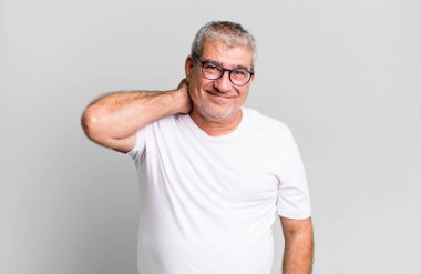 Orta yaşlı bir adam neşeli ve kendinden emin bir şekilde gülüyor, mutlu, dostane bir gülümsemeyle.