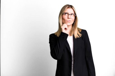 Genç, güzel bir kadın düşünüyor, kuşkulu ve şaşkın hissediyor. iş kavramı