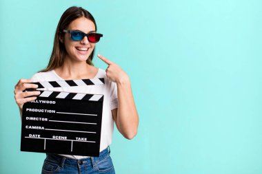 Genç ve güzel bir kadın, kendine güvenerek gülümsüyor. Sinema filmi veya film konsepti