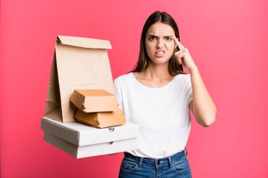 Genç, güzel bir kadın şaşırmış görünüyor, yeni bir düşünce, fikir ya da konsept fark ediyor. teslimat ve paket konsepti