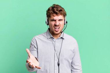 young adult caucasian man looking angry, annoyed and frustrated. telemarketer agent concept