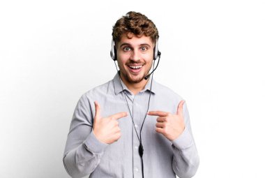 young adult caucasian man feeling happy and pointing to self with an excited. telemarketer agent concept