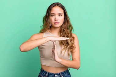 Genç ve güzel bir kadın ciddi, sert, kızgın ve hoşnutsuz görünüyor.