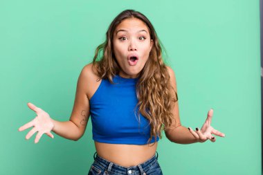 Genç ve güzel bir kadın ağzı açık ve şaşırmış, şok olmuş ve hayrete düşmüş inanılmaz bir sürprizle