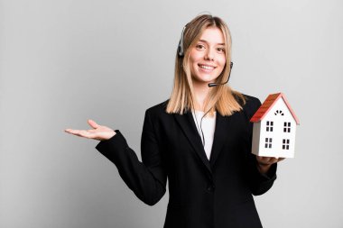 Kulaklığı ve ev modeliyle genç ve güzel bir kadın. gerçek durum kavramı