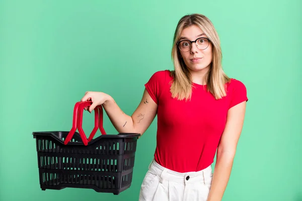 Young Pretty Woman Shrugging Feeling Confused Uncertain Empty Shopping Basket — Stok Foto