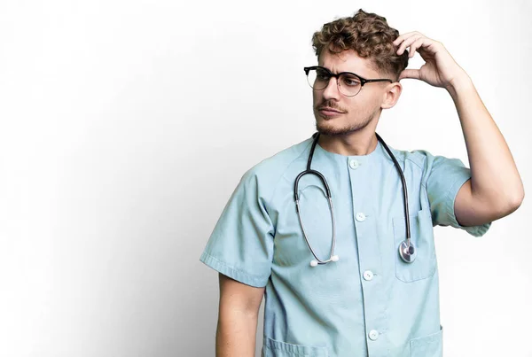 Young Adult Caucasian Man Feeling Puzzled Confused Scratching Head Nurse — Stock fotografie