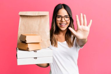 İspanyol güzel kadın gülümsüyor ve arkadaş canlısı görünüyor, beş numarayı gösteriyor. Fast food konseptini götür.