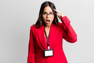 İspanyol güzel kadın şaşırmış görünüyor, akreditasyon kartı ile yeni bir düşünce, fikir ya da konsept fark ediyor.