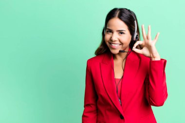 İspanyol güzel kadın kendini mutlu hissediyor, iyi bir jestle onaylıyor. tele pazarlama kavramı