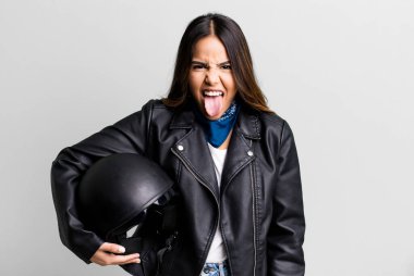 Neşeli ve asi tavırlı, şaka yapan ve dilini dışarı çıkaran İspanyol asıllı güzel bir kadın. Motosiklet sürücüsü konsepti