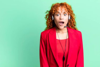 Kızıl saçlı güzel kadın çok şaşırmış ya da şaşkın görünüyor. tele pazarlama kavramı