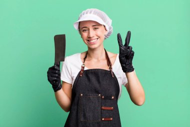 smiling and looking friendly, showing number two. butcher concept