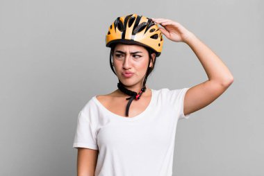 smiling happily and daydreaming or doubting. bike helmet concept