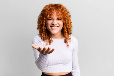 Kızıl saçlı, güzel bir kadın kızgın, sinirli ve sinirli görünüyor. Senin neyin var? 