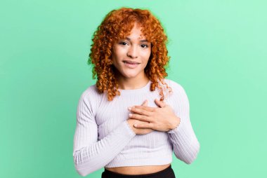 kızıl saçlı güzel bir kadın romantik, mutlu ve aşık, neşeyle gülümseyen ve kalbe yakın el ele tutuşan