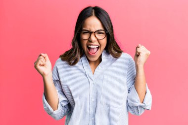 İspanyol güzel kadın son derece mutlu ve şaşırmış görünüyor, başarıyı kutluyor, bağırıyor ve zıplıyor.