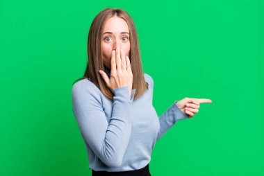 Mutlu, şaşkın ve şaşırmış hissediyorum, ağzımı elimle kapatıyorum ve yanal kopya alanını işaret ediyorum.