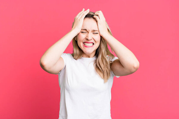 feeling stressed and anxious, depressed and frustrated with a headache, raising both hands to head