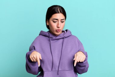 İki eliyle aşağıya doğru bakan ağzı açık, şaşkın, şaşkın ve şaşırmış bir şekilde bakan