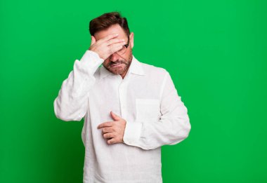 Stresli, utanmış ya da üzgün görünüyordu. Baş ağrısı vardı. Yüzü elle kaplıydı.