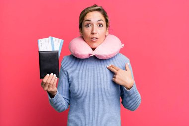 Şok olmuş ve ağzı açık, kendini işaret eden güzel sarışın bir kadın. uçuş yolcu kavramı